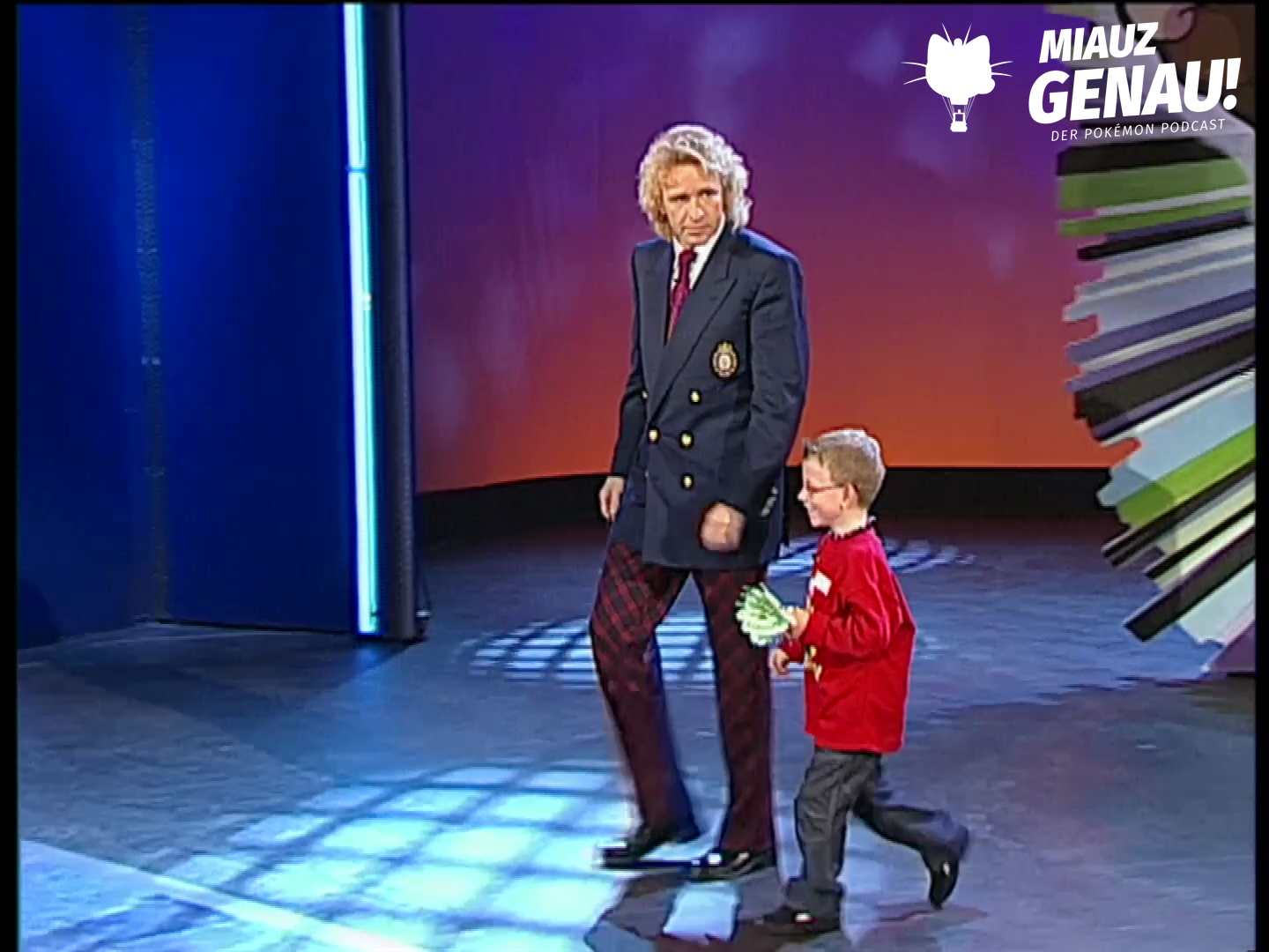 Thomas Gottschalk läuft mit Benedict Bier bei Wetten, dass..? über die Bühne, Benedict hält seinen grünen Glücksbringer in der Hand.